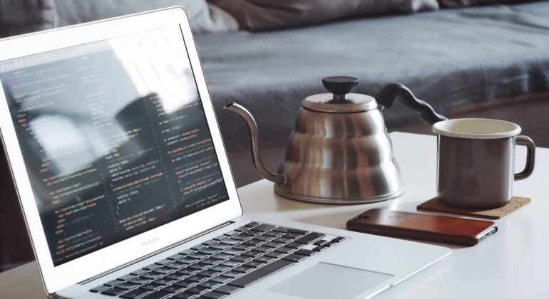 macbook and a cup of tea on the table