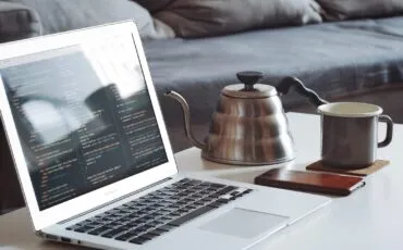 macbook and a cup of tea on the table