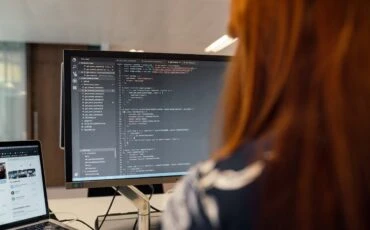 woman writing a Python code on a desktop