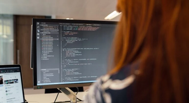 woman writing a Python code on a desktop